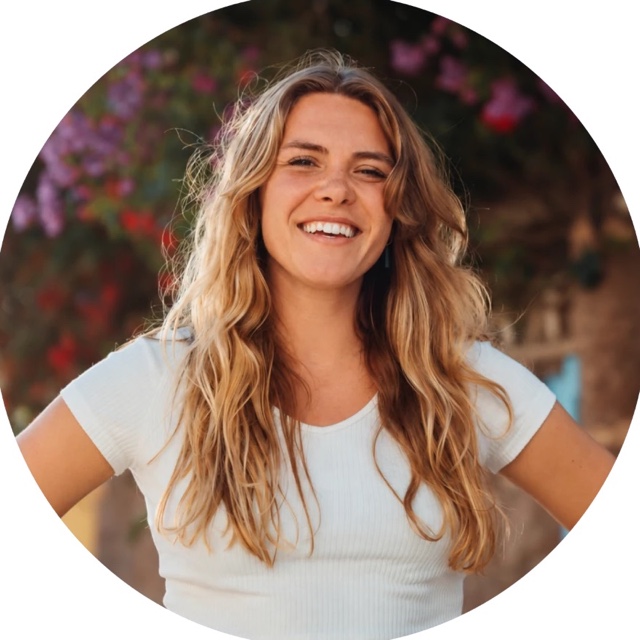 Manon Jongejan smiling in front of pink flowers