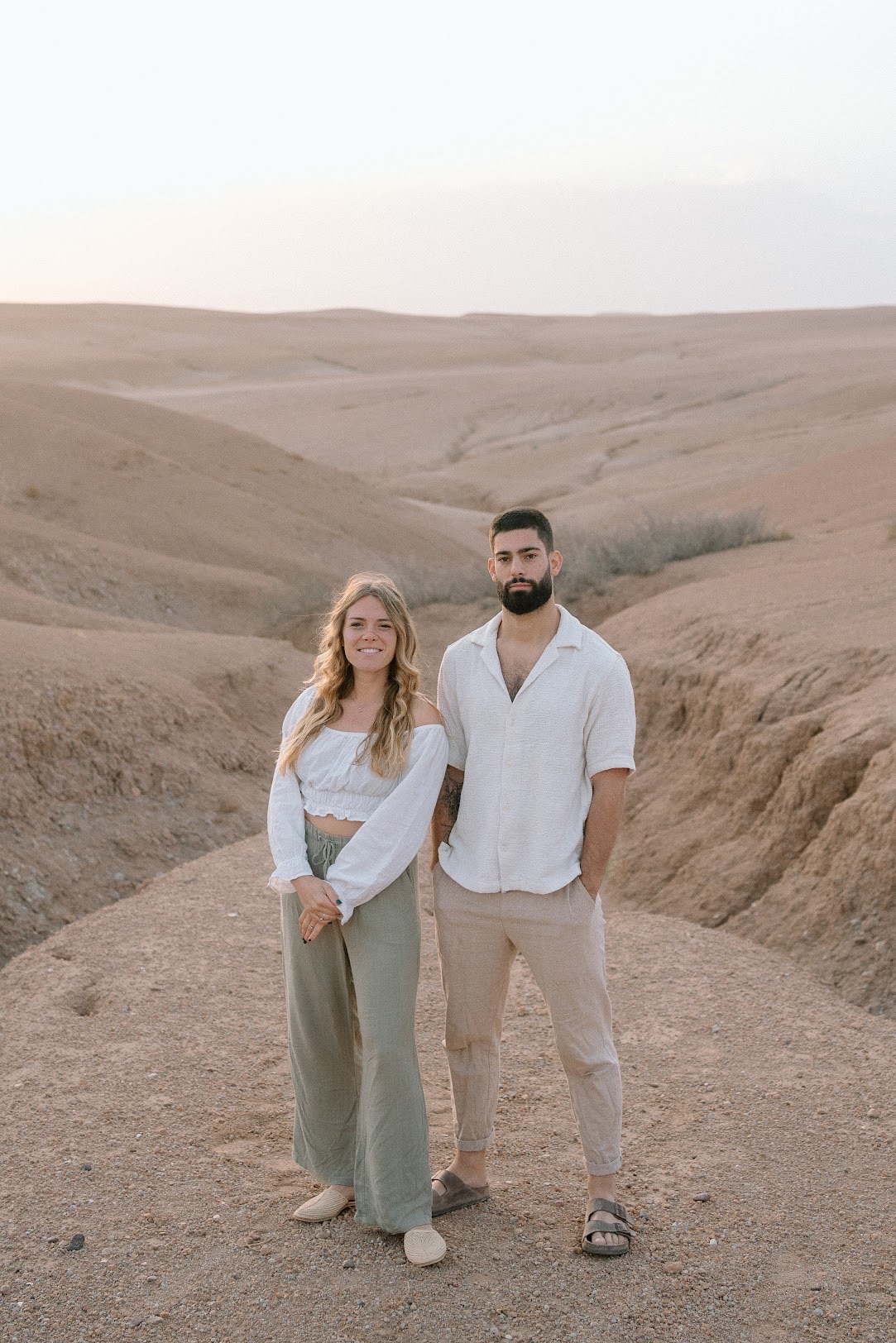Manon and Robin standing in the desert at sunset